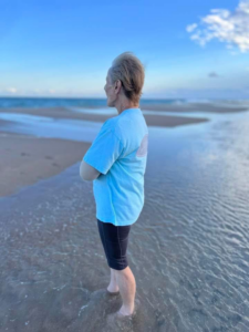 Justin Burgy’s mother standing at the beach, one of her happiest places
