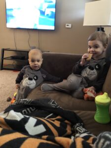My two young boys sitting together on the couch during an ordinary night at home