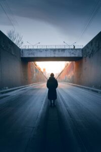 Person walking alone toward light in a tunnel, symbolizing personal journey and reflection