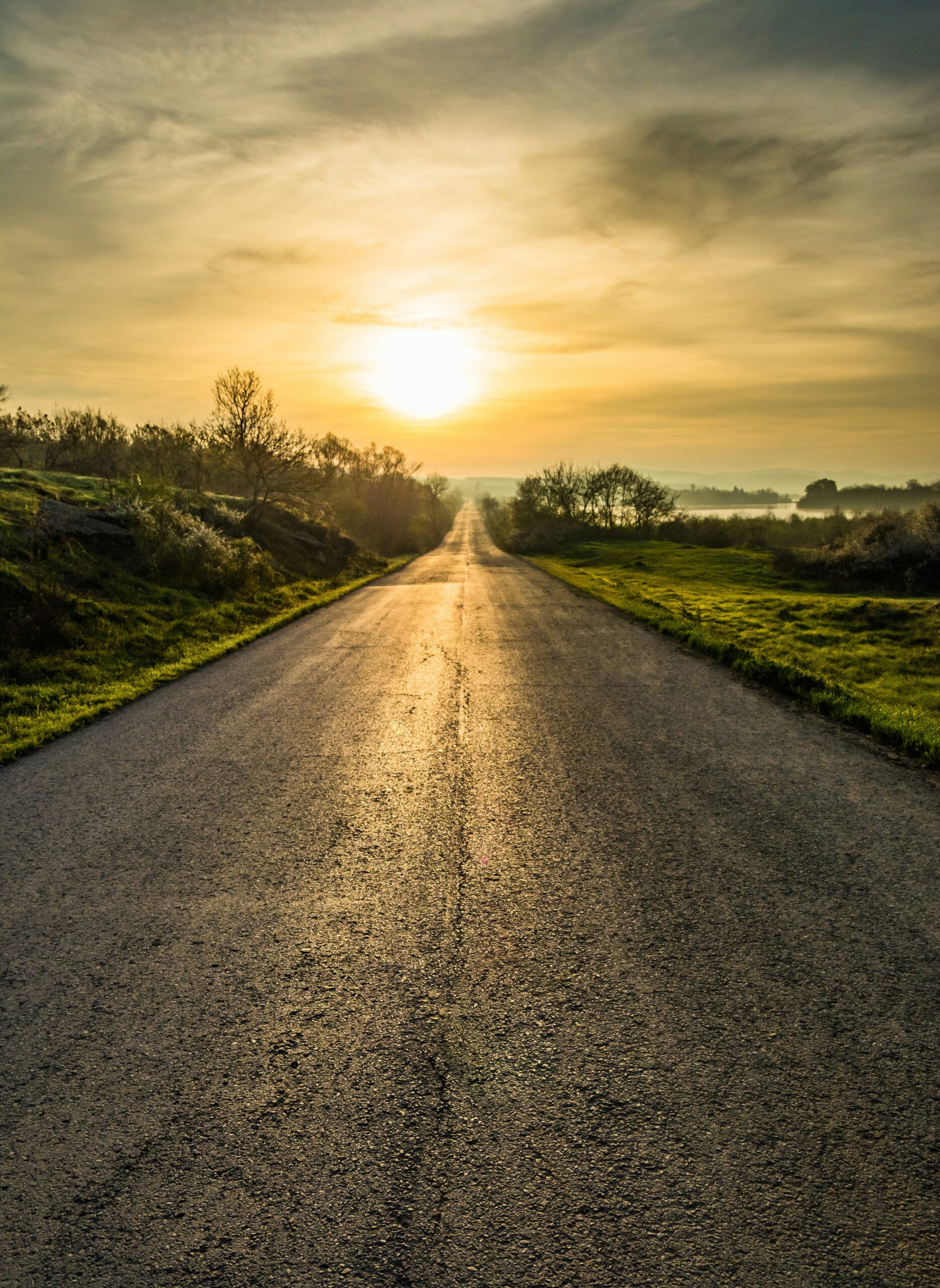 Road stretching toward a sunrise representing perseverance, growth, and reaching a meaningful goal