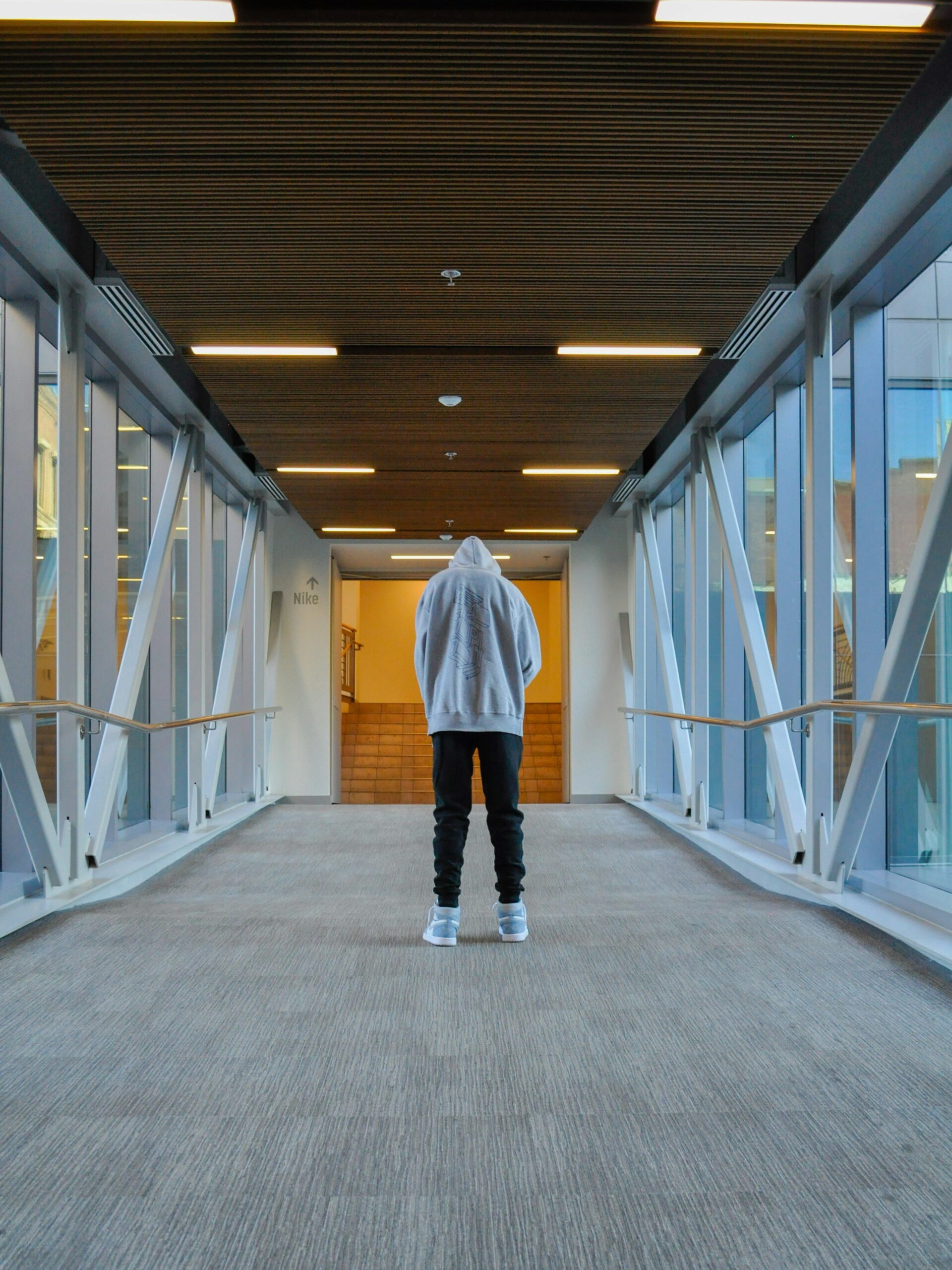Person standing alone in a hallway reflecting on how humor helped them connect with others