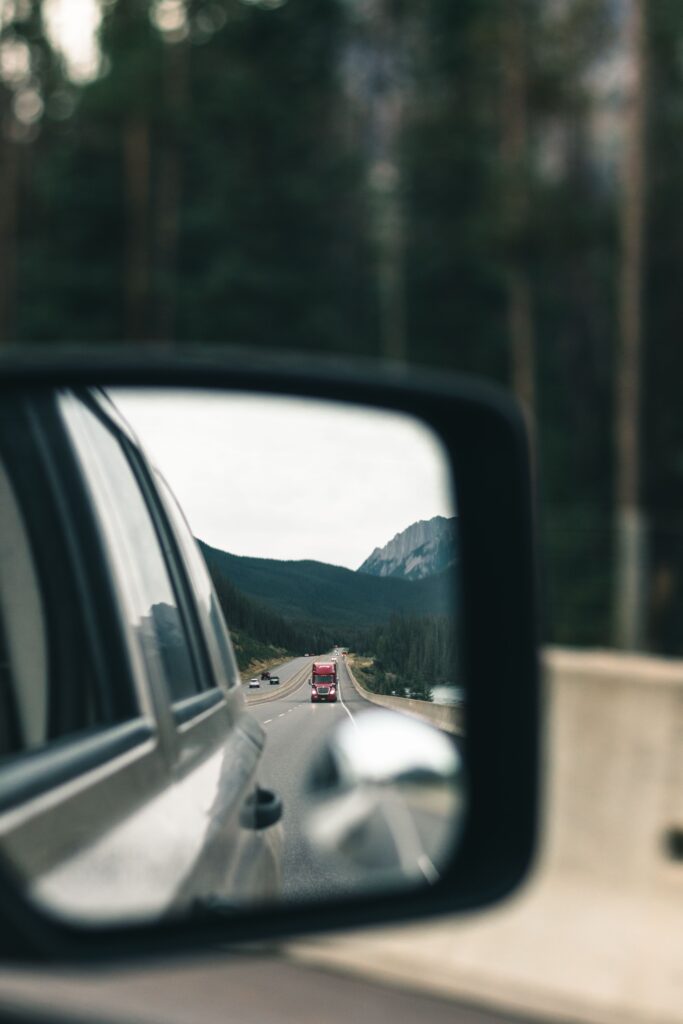 Mountain road reflected in a car side mirror while driving