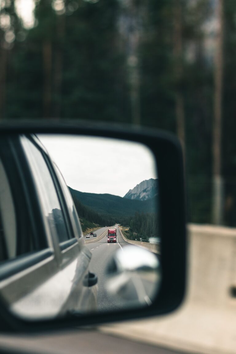 Mountain road reflected in a car side mirror while driving